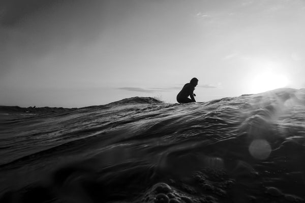 A solitary surfer waits to catch a wave